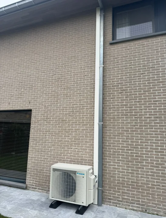 Buitenunit onder het raam aan de zijgevel