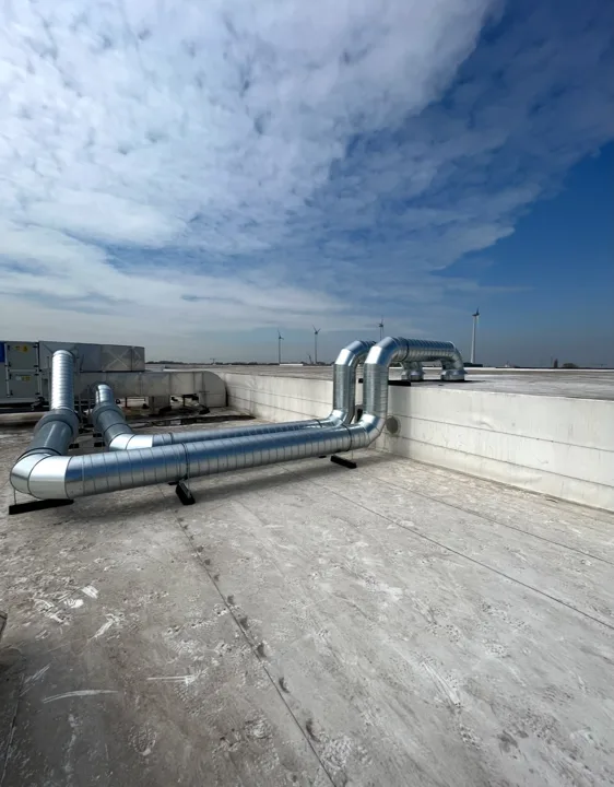 Metalen ventilatiekanalen met bochten op een plat dak